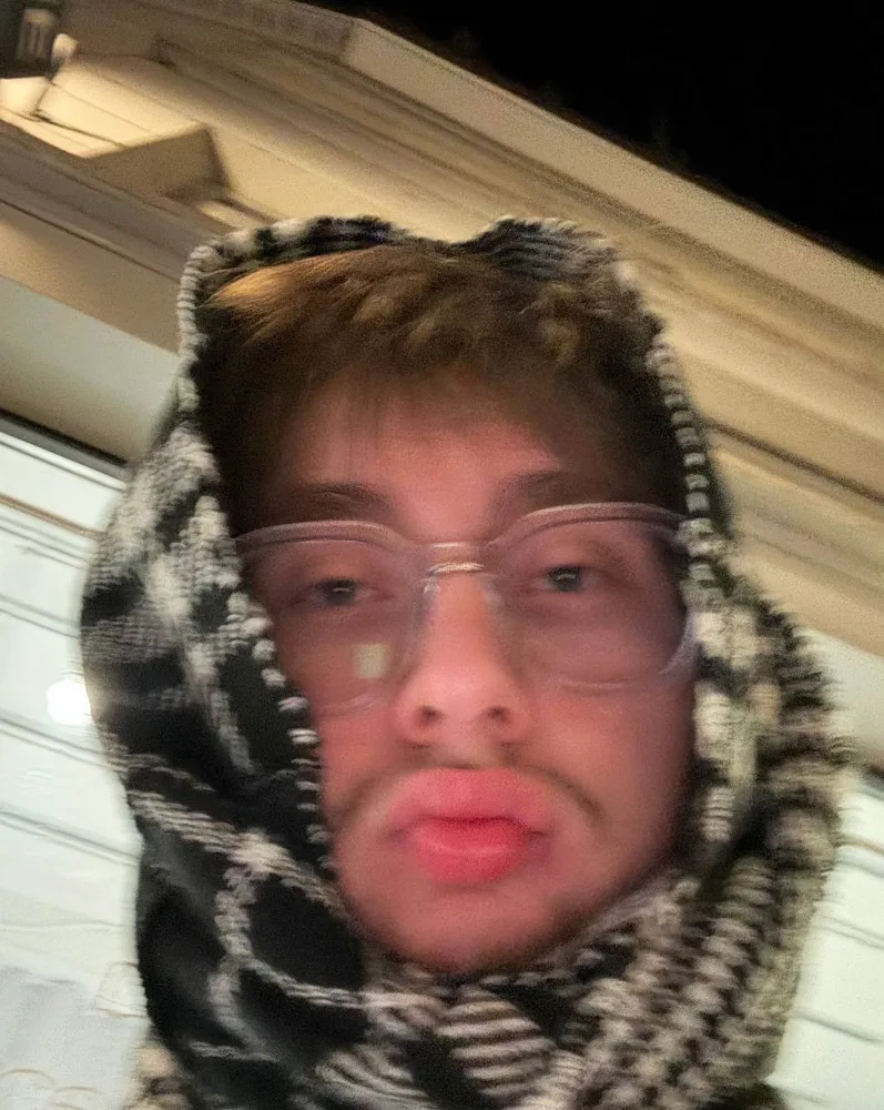 Yung Dice, close-up portrait in a patterned hood and glasses